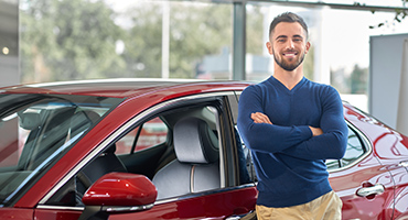 Man standing by red car